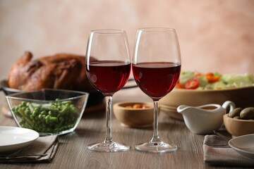 Red wine and delicious dinner served on wooden table