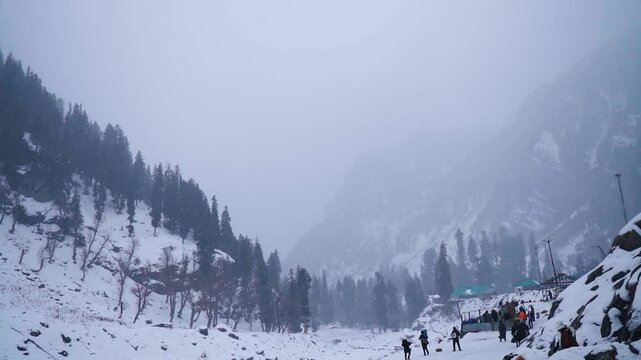 Slow motion shot of snowfall in front of snowy Himalayan mountain peaks during the winter storm as seen from Chandanwari near Pahalgam in Jammu and Kashmir, India. Snowfall in the mountain background.