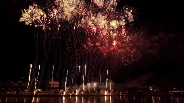 Beautiful Sparkling Colorful Fireworks in the night sky with reflections on the river Wide shot with Light Trails in the sky during Mainfest in Frankfurt Hessen Germany Deutschland