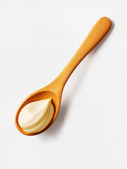 Creamy texture of mayonnaise on a wooden spoon against a plain background in natural lighting