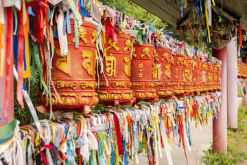 Rotating religious elements for touching turning spinning Buddhist prayer wheel at Buddhist monastery. Prayer wheels in Buddhist stupa temple. Buddhism religion concept