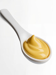Creamy yellow mustard on a spoon, ready for use in various dishes and condiments in a modern kitchen setting