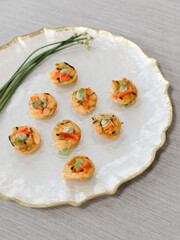 Delicate appetizers featuring fresh vegetables and seafood on an elegant serving plate