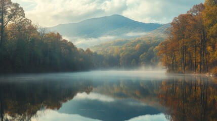 Fototapeta premium Autumnal lake mirroring misty mountain and trees