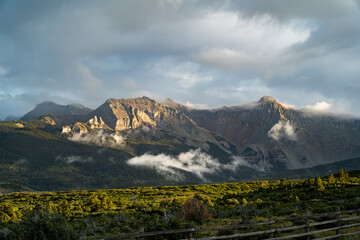 Scenic Mountain Range With Clouds and Lush Forested Landscapes