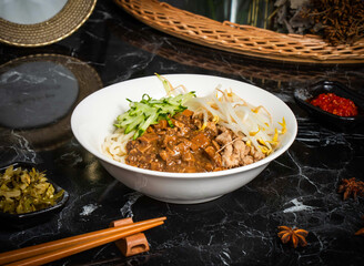 Shredded Pork Noodles with cucumber, Soy Sauce, and chopsticks served in bowl isolated dark background side view of taiwan food
