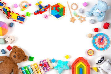 Baby kids toys frame with copy space for text. Colorful educational wooden, plastic and fluffy toys on white background. Top view, flat lay