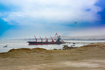 A cargo ship being loaded with copper concentrate at a port on the coast of the Atacama Desert in Chile.