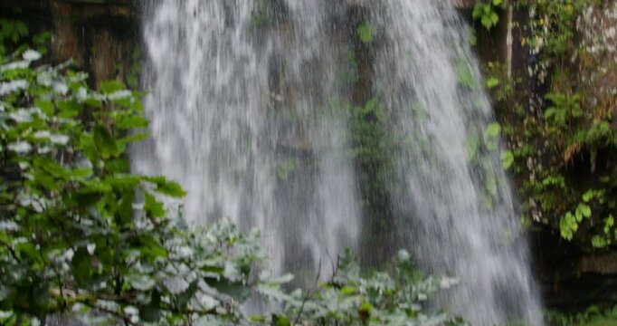 Extra wide shot Tilting down the Melin Court waterfall at Melin Court nature reserve