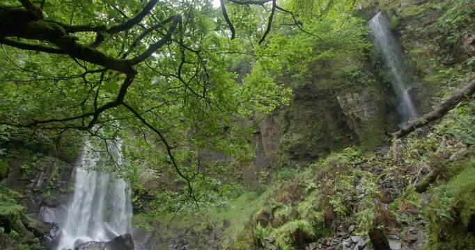 Slow pan of the 2 waterfalls of Melin Court waterfall at Melin Court nature reserve