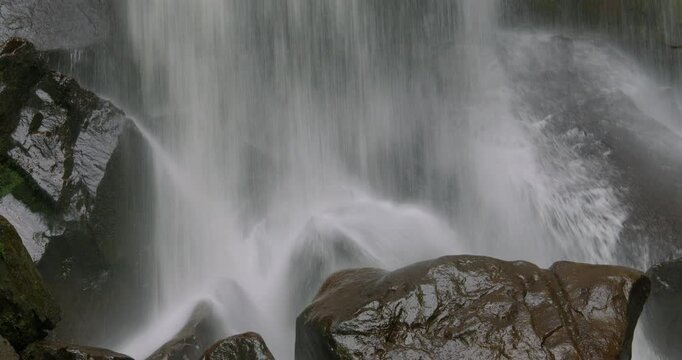 Close up shot of the base of the Melin Court waterfall with rocks. at Melin Court nature reserve