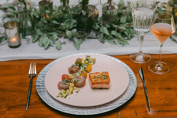 Elegant dining experience featuring gourmet salmon dish with fresh vegetables at a beautifully arranged table setting