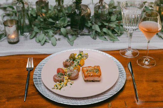 Elegant dining experience featuring gourmet salmon dish with fresh vegetables at a beautifully arranged table setting