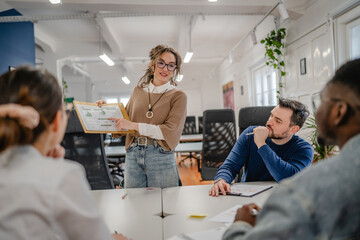 Obraz premium young businesswoman representing statistics to her work team