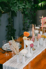 Elegant dining table arrangement with flowers and candles at a modern event venue during an afternoon gathering