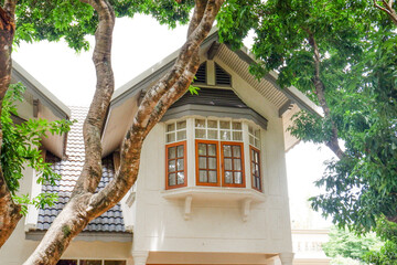 Cozy Houses in suburb with Spring season and tree in backyard, Large estate home building Window Frame,terrace of a ground floor house with wooden chair and table.