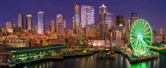 Seattle skyline at twilight, illuminated Ferris wheel, and waterfront buildings. Evening city views. Waterfront, Seattle, Washington, USA