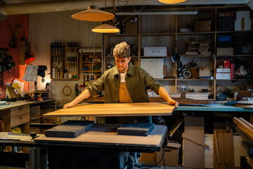 Man joiner makes custom table from solid wood in shop workshop. Precision craftsmanship, custom design, handcrafted furniture, durable materials, tailored piece, manual labor, furniture making