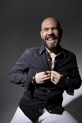 Portrait of mature and happy man with beard, posing confidently indoors. 
