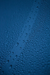 water drops on the blue metal surface, abstract background, and macro window after the rain, blue car after carwash 