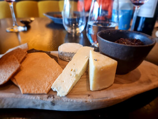 Gourmet cheese platter served with crackers and fruit preserve in upscale dining setting