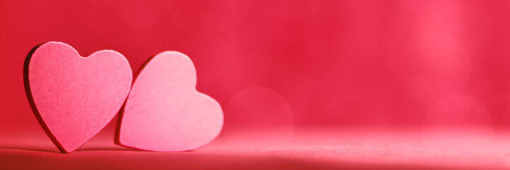 A close-up of two soft red heart shapes placed on a bright red background, showcasing love and romance with a contemporary artistic style and soft aesthetic.