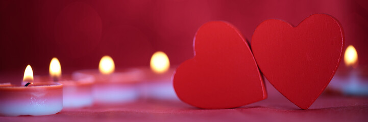 This image captures two red heart shapes against a soft, blurred background with a row of...