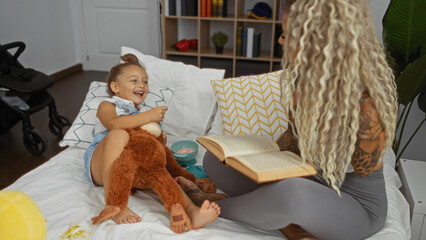 Woman reading to daughter on bed indoors creating a warm family moment in a cozy home environment filled with laughter and love.