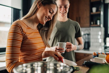 Lesbian couple preparing food and smiling in kitchen