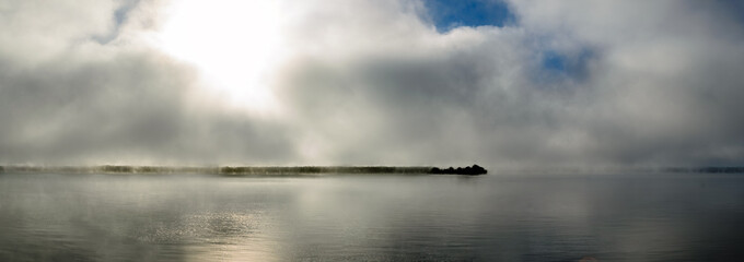 Panorama of morning fog clearing over the St. Lawrnence River showing the far coastline.