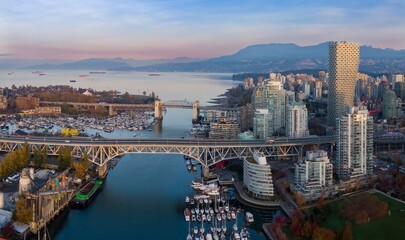 Naklejka premium Vancouver skyline at dawn, featuring the Granville Bridge, numerous boats, and modern high-rise buildings. Cityscape, bridge, and harbor. Vancouver, British Columbia, Canada