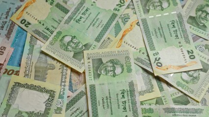 Bangladeshi taka banknotes are spread out, showcasing various denominations and vibrant designs from bangladesh's currency.