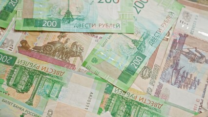 Russian ruble banknotes scattered in a disorganized manner showcasing various denominations and intricate designs.