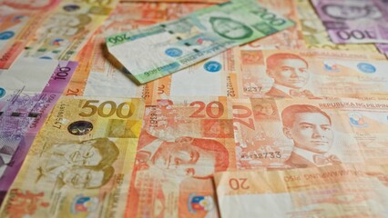 Colorful philippine pesos showcasing various denominations of banknotes intricately placed together, highlighting the vibrant and detailed design elements.