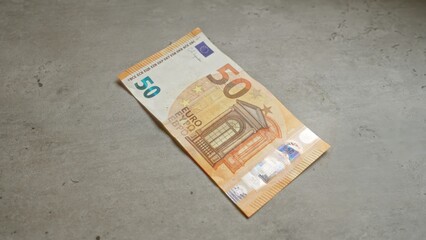 Euros on concrete surface, focusing on 50 euro banknote from european union