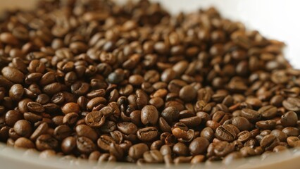 Roasted coffee beans arranged on a white surface reflecting rich brown hues and smooth textures, emphasizing their quality and freshness.