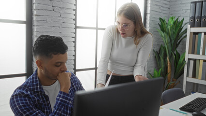 Woman discussing with man in bright office, surrounded by natural elements and modern furniture,...