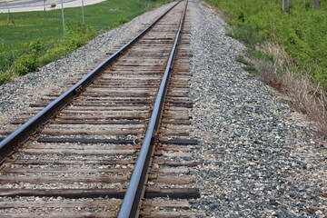 Fototapeta premium close-up view along a rail line with worn wooden ties and gravel bed