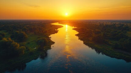 Golden sunset over meandering river through vast flatlands with vibrant sky and reflection