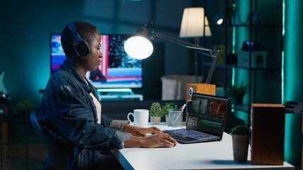 Video editor adds sound effects to filmed footage, working in home studio. Videographer using...