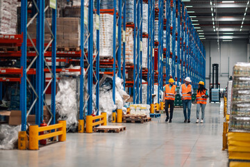 Warehouse workers walking and discussing logistics in a storage facility