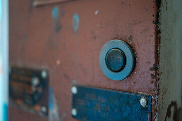 Doorbell on a Rustic Metal Door with Signs of Wear and Age