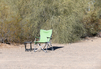Camping Chair and Table sitting alone in the desert sand