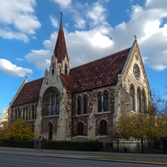 Fototapeta premium Majestic Church Stands Tall with Intricate Stonework and Red Tile Roof against a Blue Sky