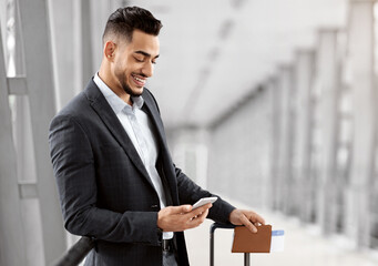 Booking Hotel Online. Young Arab Businessman Using Smartphone While Waiting In Airport, Middle...