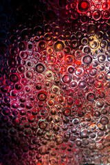 circles wallpaper in pink and red tones.multicolored light in circles backgroundTextured wall with light . textured glass background.