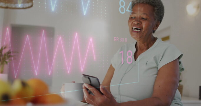 Image of cardiograph over senior biracial woman using smartphone at home - Powered by Adobe