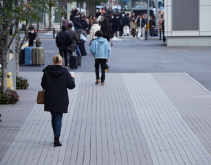 冬の昼の大都市の街で歩く人々の姿