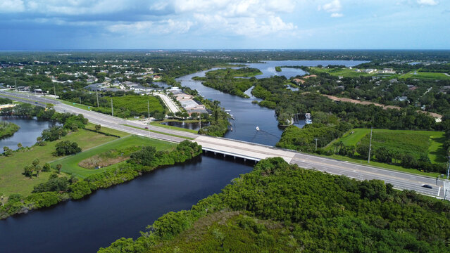 Aerial (drone) view of upper Braden River at SR 70 in Bradenton, FL. Beautiful Florida river with lush greenery, houses, and a building storm in the distance.