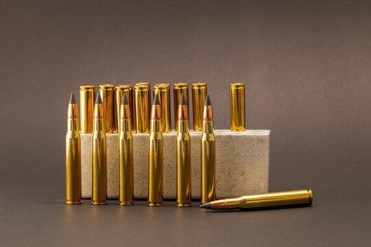 Hunting ammunition: 30-06 cartridges with polished brass casings and black ballistic tips on a dark background.